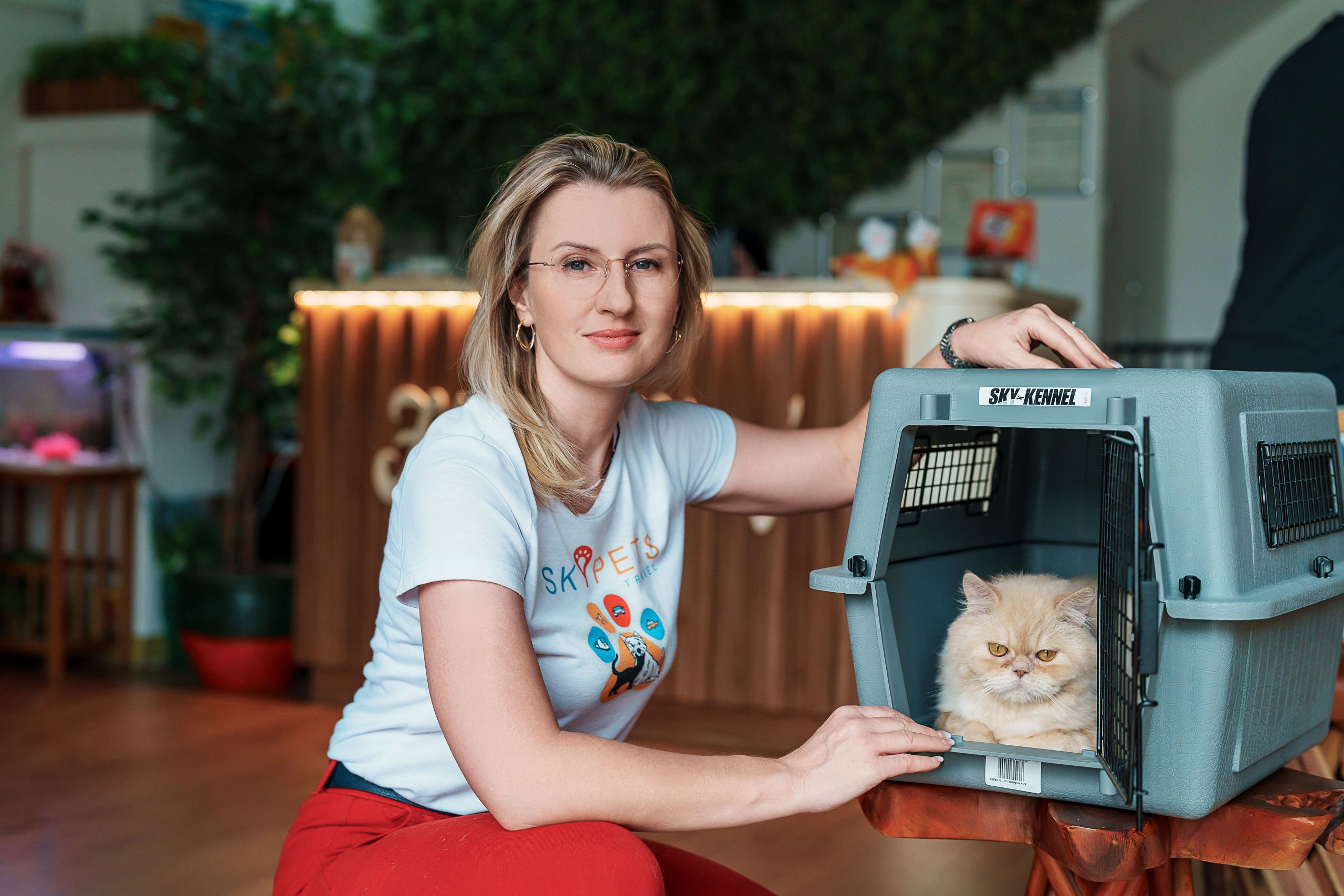 SkyPets Travel team member beside a cat in a travel crate